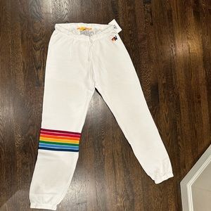 Aviator Nation women’s white sweatpants with rainbow stripes wrapped around leg